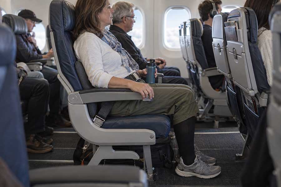 Traveler relaxing calmly during turbulence with headphones and a book