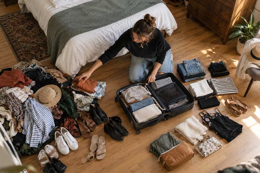 A traveler working to pack a lighter suitcase