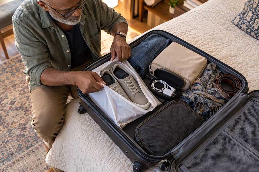 A traveler with a finished packing list and an organized suitcase ready to go