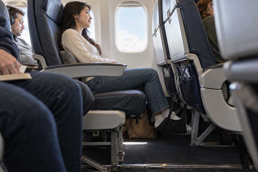 A traveler wearing headphones comfortably during a flight