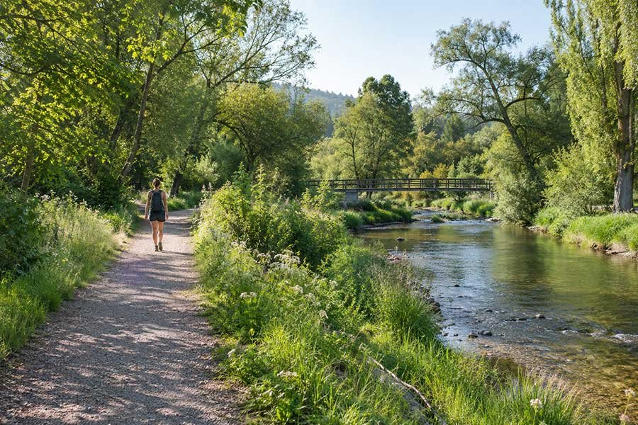 Traveler enjoying a refreshing walk along a quiet river path on a weekend getaway