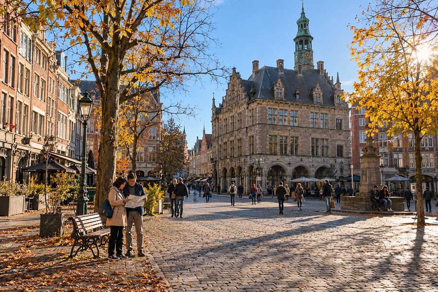 Autumn morning in a historic city square with soft light on old buildings and fall trees
