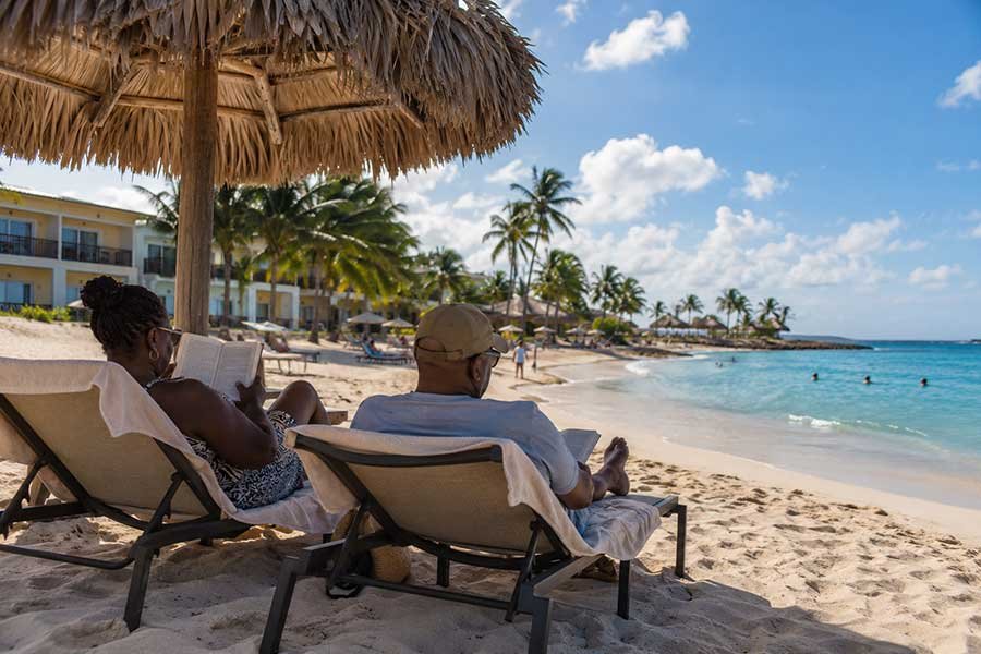Couple unwinding with drinks by the pool at a Caribbean all-inclusive resort