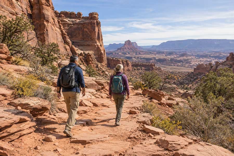 Hikers walking a red rock trail on a crisp Thanksgiving weekend adventure