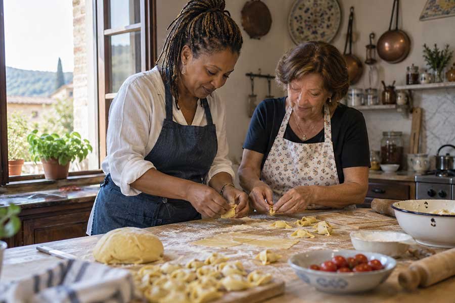 Traveler shaping fresh pasta by hand in a family kitchen during a cooking lesson