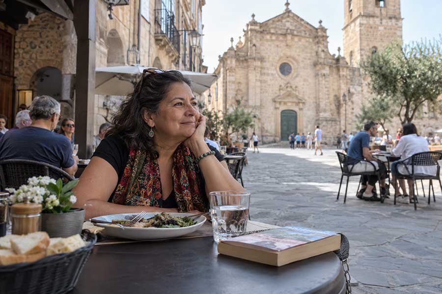 Solo traveler enjoying a relaxed lunch at a table in a historic square
