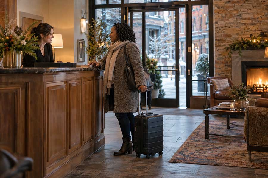 Solo traveler arriving at a boutique hotel on a winter evening for a holiday getaway