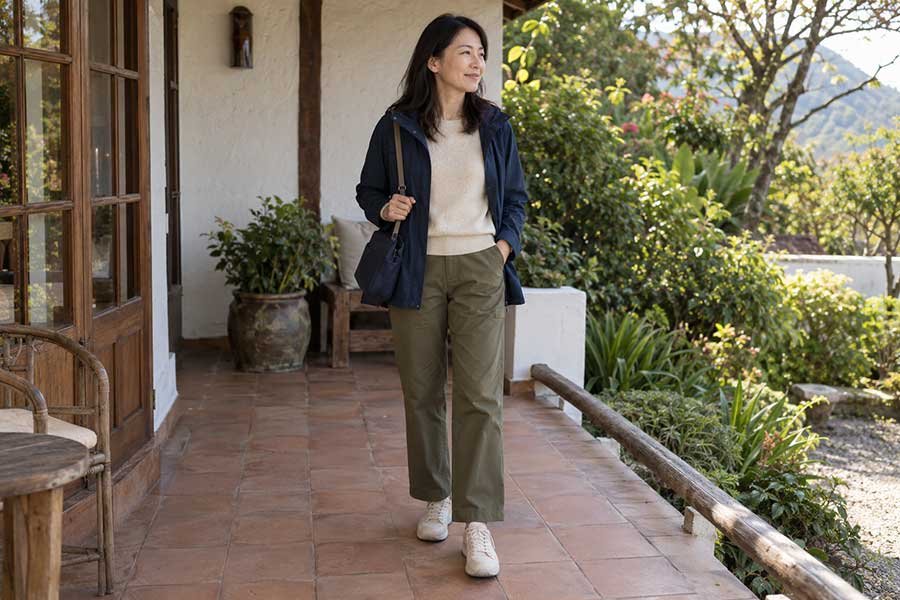 Traveler ready for dinner on a terrace in coordinated navy, cream, and olive clothes